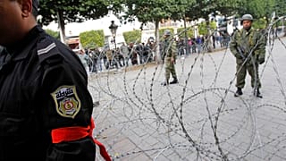 ضابط شرطة يرتدي شارة حمراء في تونس العاصمة، السبت 22 يناير 2011.