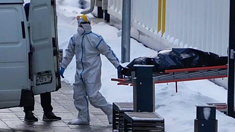 Medical workers carry a body to a van outside a COVID-19 hospital in Kommunarka, outside Moscow