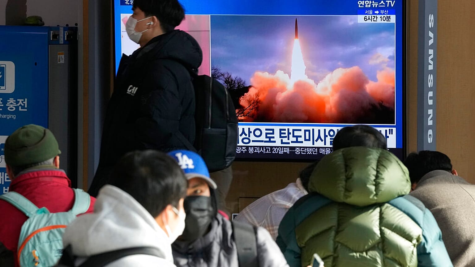 Des personnes regardant une télévision diffusant une image d'archive du lancement d'un missile de la Corée du Nord, à Séoul, en Corée du Sud, dimanche 30 janvier 2022. 