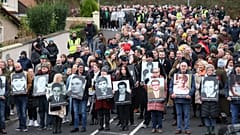 People take part in a march to commemorate the 50th anniversary of the 'Bloody Sunday' shootings with the photographs of some of the victims in Londonderry, Sunday