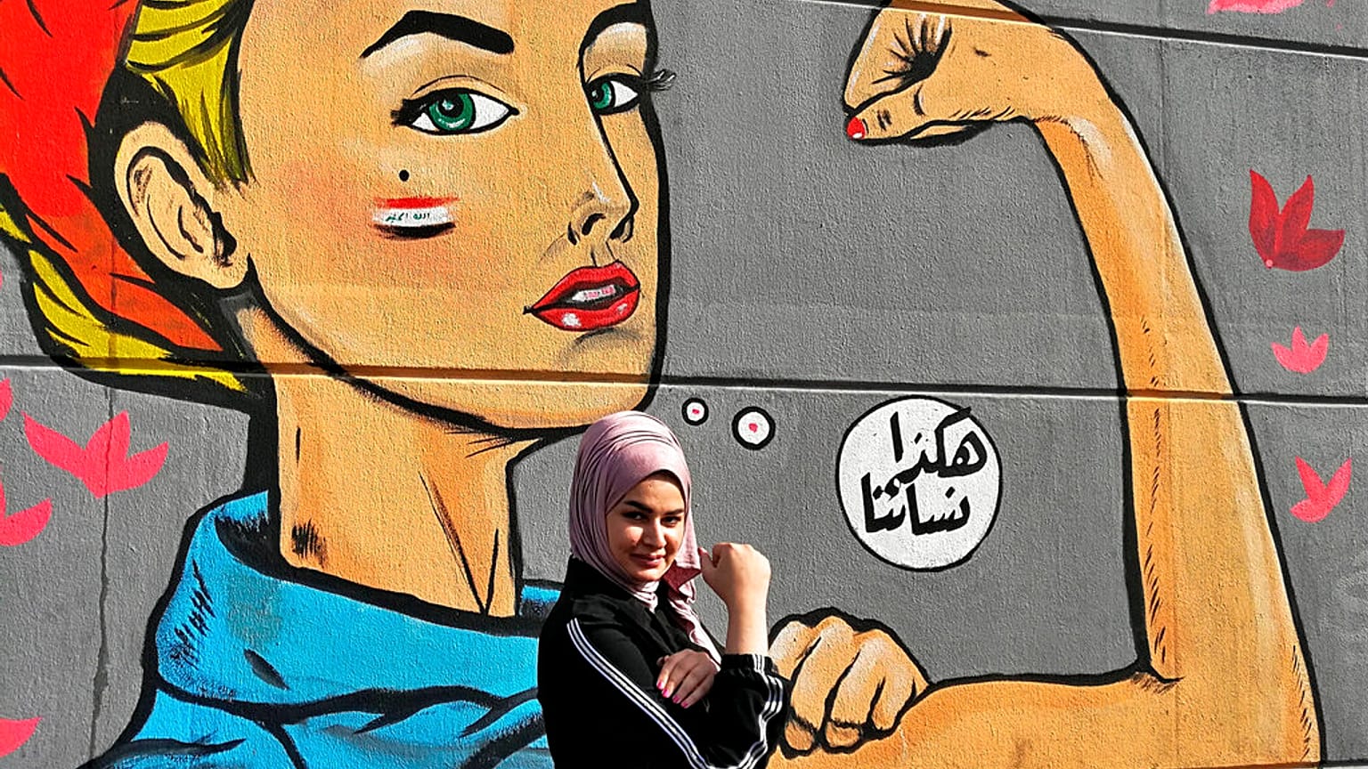 امرأة تقف لالتقاط صورة بالقرب من غرافيتي كتب عليه بالعربية "هكذا نسائنا"، بالقرب من ساحة التحرير في بغداد، العراق، الخميس 7 نوفمبر 2019