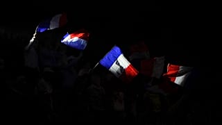 Supporters of far-right presidential candidate Eric Zemmour wave French flags during a campaign rally at the Palais des Victoires in Cannes,
