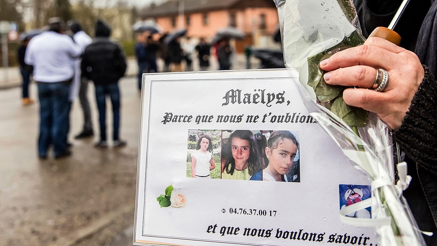 People hold pictures of Maelys de Araujo during a "white march" tribute in December 2017.