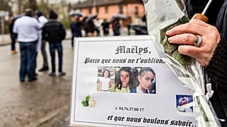 People hold pictures of Maelys de Araujo during a "white march" tribute in December 2017.