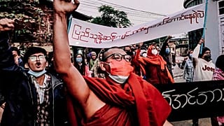 A Buddhist monk raises his clenched fist while marching during an anti-military government protest rally on Tuesday, Feb. 1, 2022, in Mandalay, Myanmar.