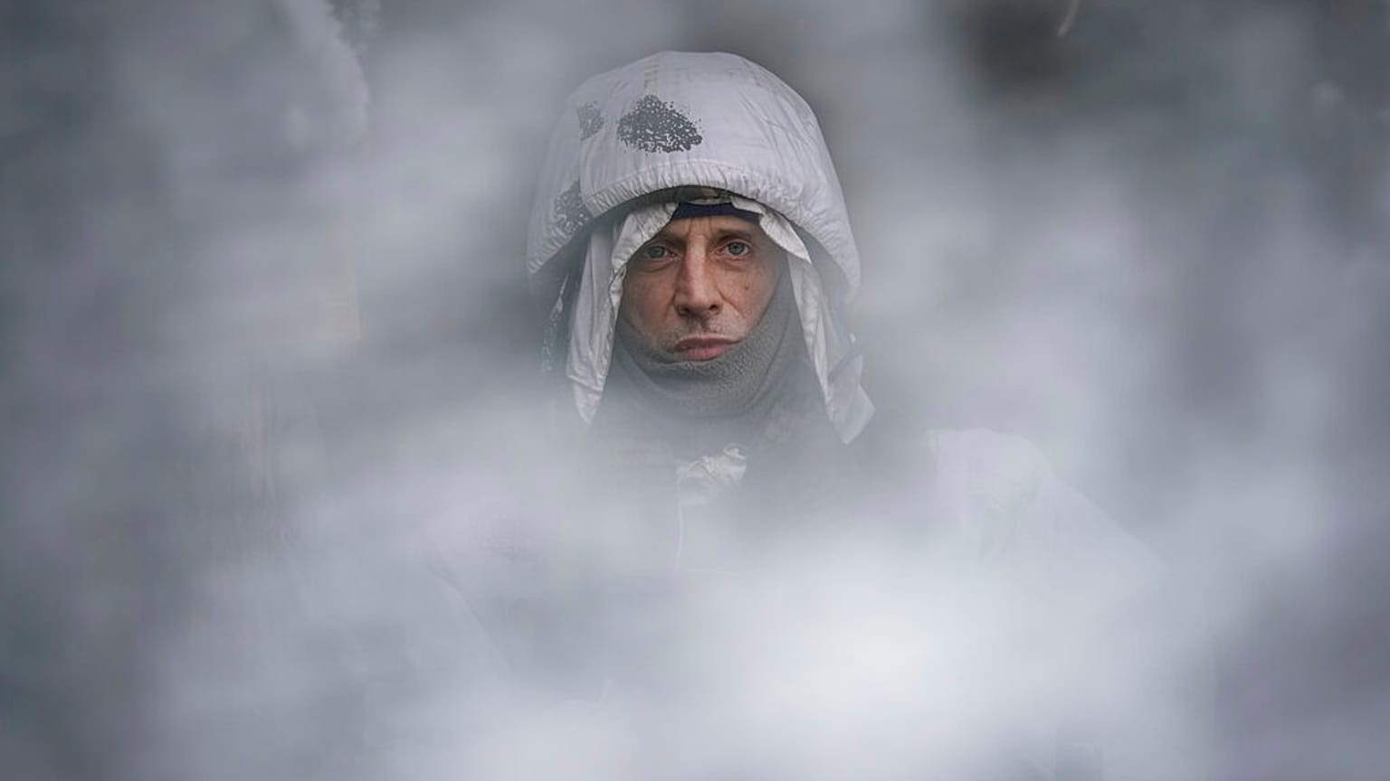 Un soldat ukrainien photographié à travers une maille de camouflage sur la ligne de front dans la région de Louhansk, dans l'est de l'Ukraine, samedi 29 janvier 2022. 
