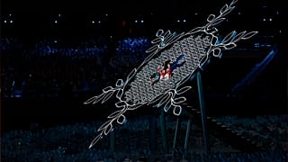 China's athletes Dinigeer Yilamujian and Zhao Jiawen prepare to light the cauldron during the opening ceremony of the 2022 Winter Olympics