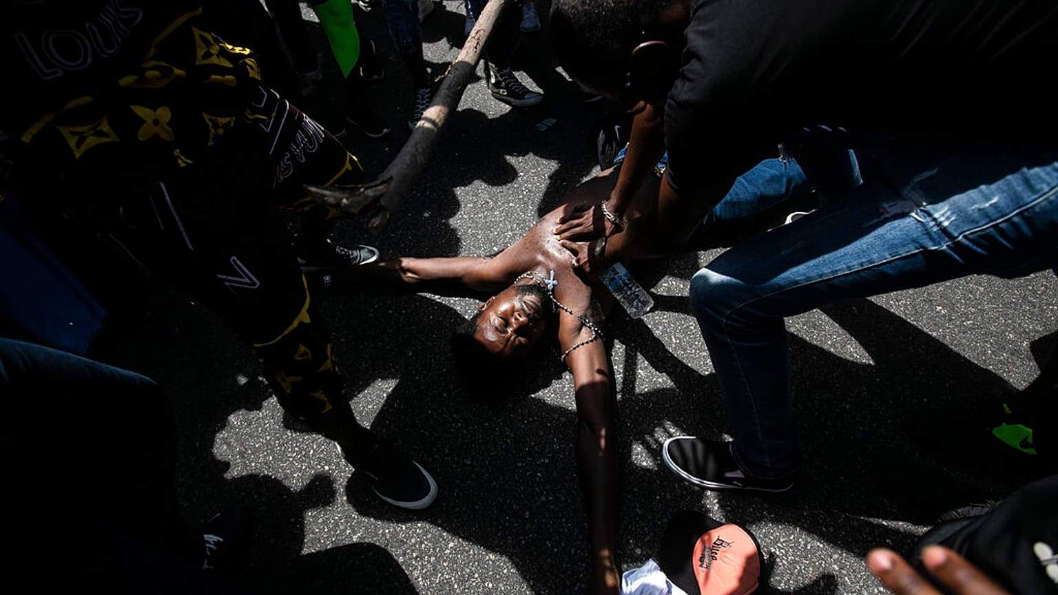 Un manifestante simula la muerte violenta de Moïse, un inmigrante congoleño, en Río de Janeiro (Brasil)