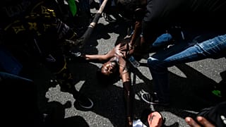 Un manifestante simula la muerte violenta de Moïse, un inmigrante congoleño, en Río de Janeiro (Brasil)