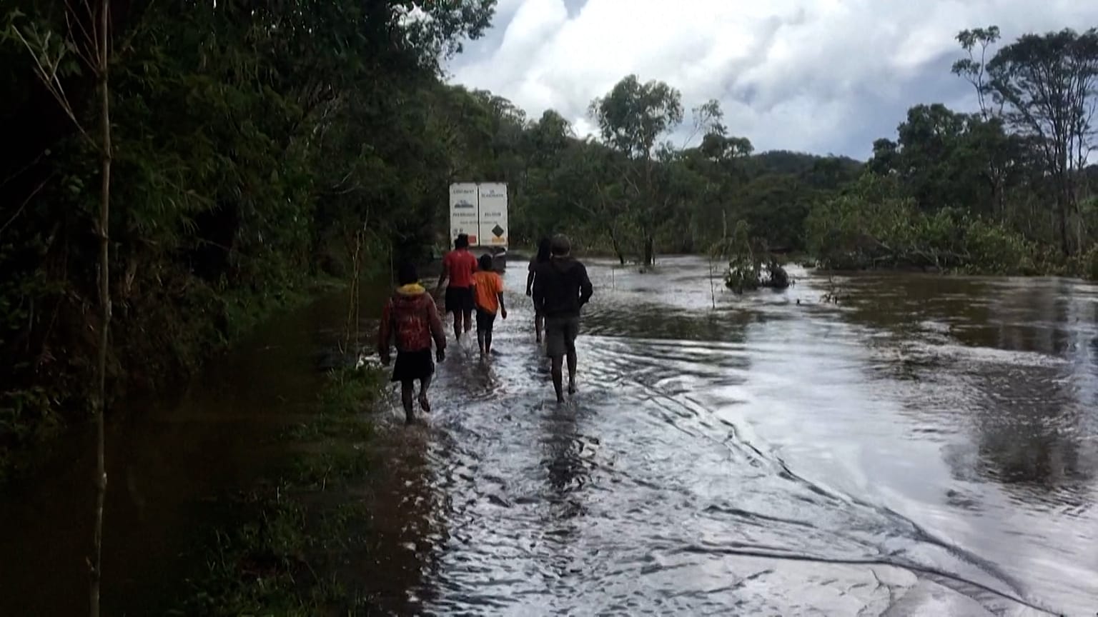 People walking by a flooded road
