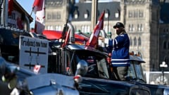 Demonstrant in Ottawa befestigt eine mit Gitterstäben geschmückte Fahne auf seinem Lkw - Aufschrift: "Trudeaus neues Zuhause".