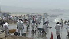 Decenas de personas contratadas recogen crudo en las costas de Perú. 