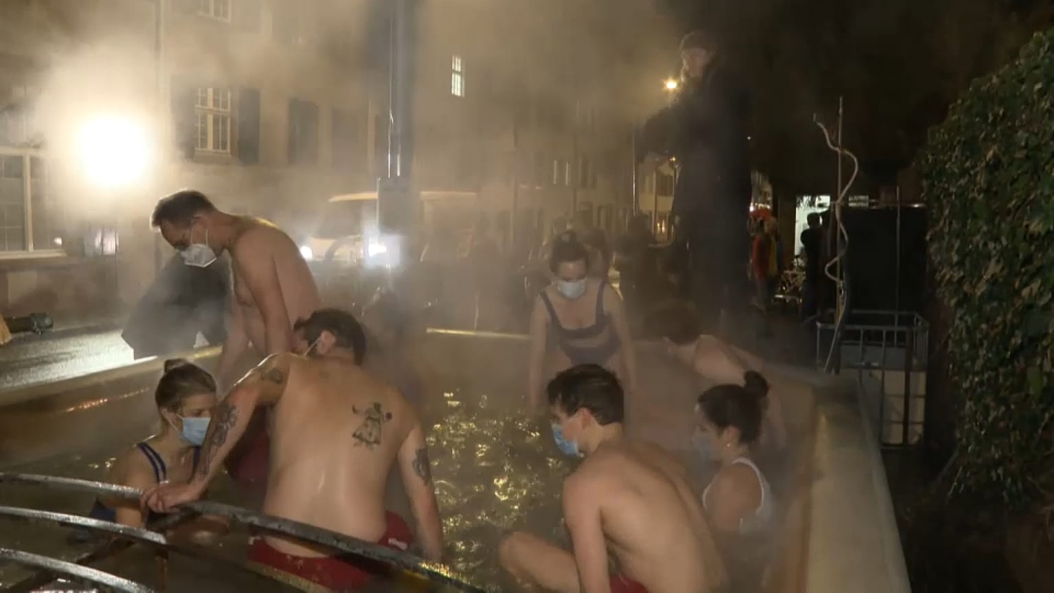 Draußen ist es kalt - aber im Wasser schön warm: Nach der Arbeit gehen diese Basler:innen baden - im Stadtbrunnen.