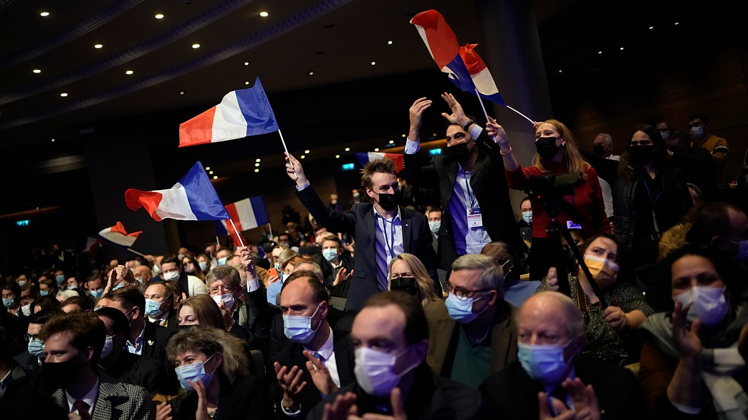Fans wave French flags as Valerie Pecresse, candidate for the French presidential election 2022, delivers a speech during a meeting in Paris, France on 11 December 2021.