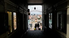 Um casal transporta malas de viagem em Lisboa