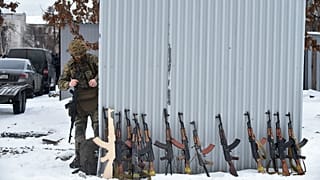 A military instructor looks at at Kalashnikov rifles and wooden replicas prior to a training session at an abandoned factory in the Ukrainian capital of Kyiv on February 6.