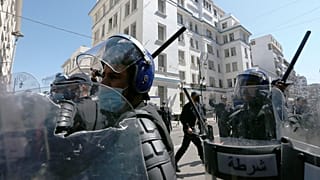 افراد من الشرطة الجزائرية يشهرون هراواتهم خلال مظاهرة في الجزائر - أرشيف