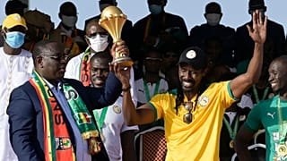  Präsident Macky Sall stemmt den Siegerpokal mit Trainer Aliou Ciss´é