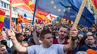 People waving national and EU flags gather at a rally in Skopje, April 2019