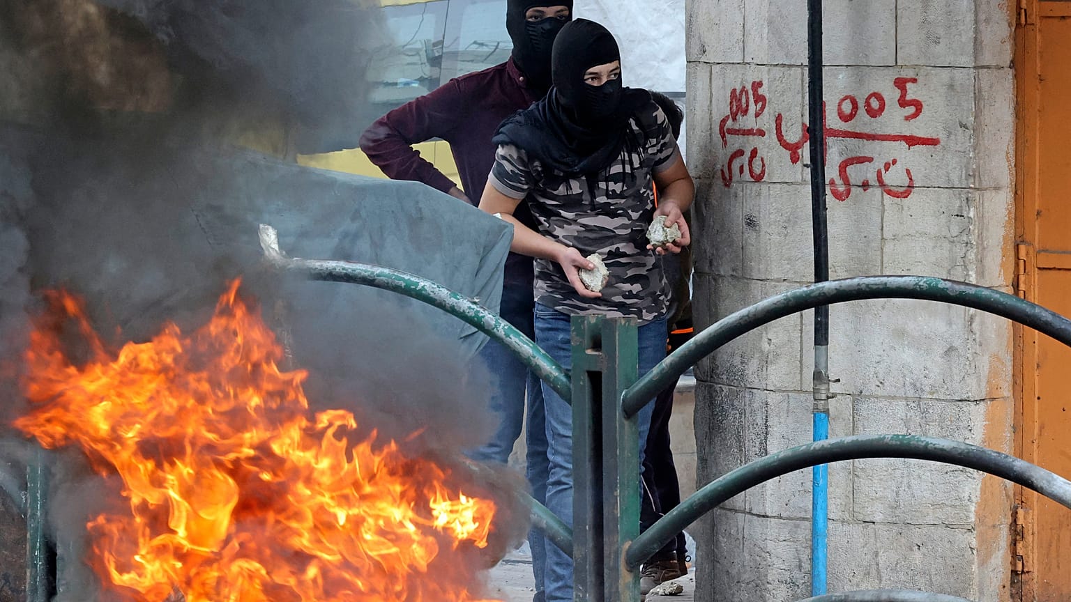 شابان فلسطينيان في الخليل بالضفة الغربية يستعدان لرشق جنود الاحتلال بالحجارة في إطار المواجات التي تشهدها العديد من المدن الفلسطينية عقب مقتل 3 شبان برصاص جنود إسرائيليين