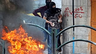 شابان فلسطينيان في الخليل بالضفة الغربية يستعدان لرشق جنود الاحتلال بالحجارة في إطار المواجات التي تشهدها العديد من المدن الفلسطينية عقب مقتل 3 شبان برصاص جنود إسرائيليين