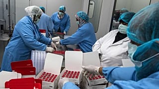 عمال المختبر يملأون الصناديق بقوارير من لقاح سينوفاك الصيني ضد فيروس كورونا، الذي تنتجه شركة فاكسيرا المصرية بالعاصمة القاهرة، 1 سبتمبر 2021