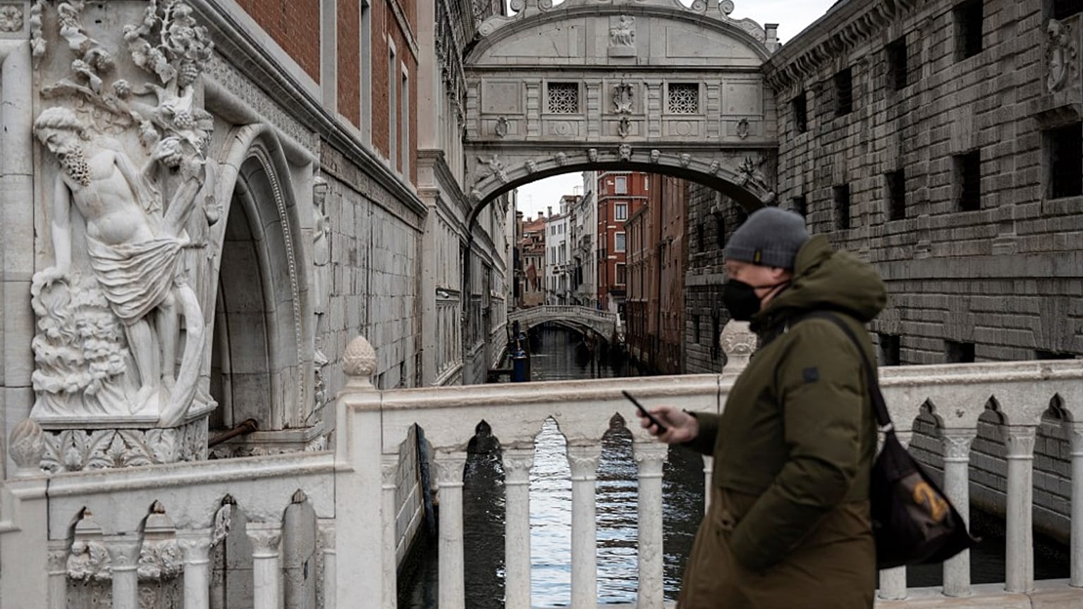Homem com máscara passeia em Veneza, Itália
