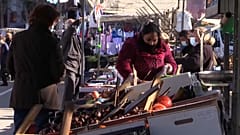 Transeúntes caminan con mascarilla en un mercado en Madrid. 