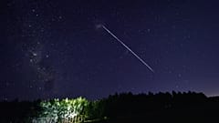 FILE- In this file photo taken on February 06, 2021, this time-exposure image shows a trail of a group of SpaceX's Starlink satellites passing over Uruguay