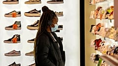 A woman wears a protective mask as she looks at shoes in Rue Neuve in Brussels, Belgium, Saturday, Nov. 27, 2021.