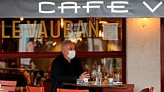 A man wearing mask sits on a cafe terrace in Saint Jean de Luz, southwestern France, Monday, Oct. 12, 2020