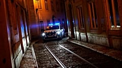 A police car drives through a narrow street of the old Alfama neighbourhood in Lisbon.