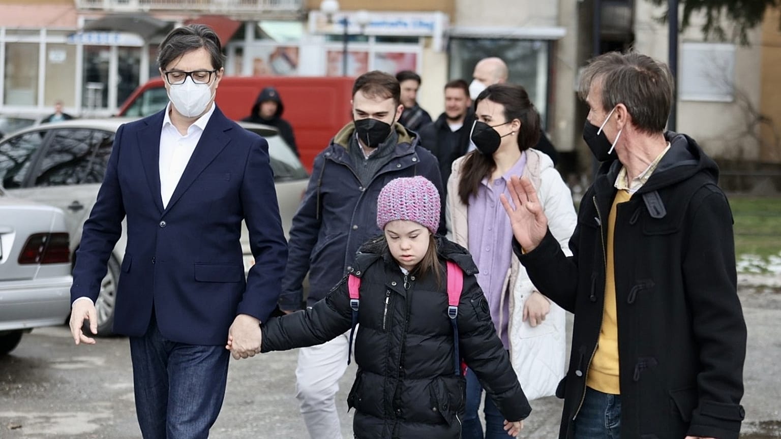 The President of the Republic of North Macedonia, Stevo Pendarovski, holds the hand of Embla Ademi as he walks her to school on February 7, 2022.