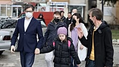 The President of the Republic of North Macedonia, Stevo Pendarovski, holds the hand of Embla Ademi as he walks her to school on February 7, 2022.