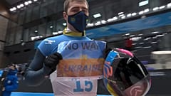 Vladyslav Heraskevych, of Ukraine, holds a sign that reads "No War in Ukraine" after a run at the men's skeleton competition at the 2022 Winter Olympics, Feb 11, 2022.