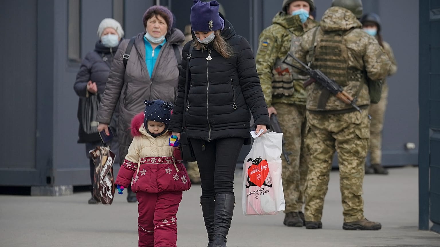 A woman holds a child's hand as they cross from Ukrainian government to pro-Russian separatists controlled territory in Stanytsia Luhanska.