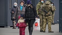 A woman holds a child's hand as they cross from Ukrainian government to pro-Russian separatists controlled territory in Stanytsia Luhanska.