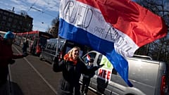 Una mujer con una bandera neerlandesa en la que se lee "libertad para nuestros hijos" en la entrada de la sede del Gobierno en La Haya, Países Bajos, el 12 de febrero de 2022.