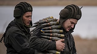 A Ukrainian serviceman carries large caliber ammunitions for armoured vehicles mounted weapons during an exercise in a Joint Forces Operation controlled area in Donbas