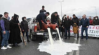مزارعون يسكبون الحليب في اليونان