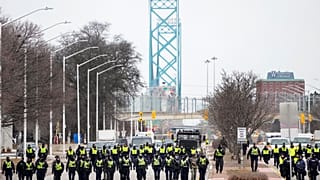 La police avance en ligne pour expulser les manifestants du pont Ambassador à Windsor qui relie Canada et Etats-Unis, le 13 février 2022