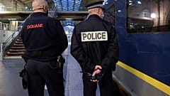 A French Border Police officer (L) and a National Police officer stand near an Eurostar train in Gare du Nord station in Paris on December 10, 2020.