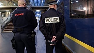 A French Border Police officer (L) and a National Police officer stand near an Eurostar train in Gare du Nord station in Paris on December 10, 2020.
