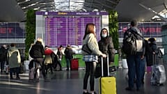 Travellers wait at the the departures board ahead of their flights at the Boryspil airport some 30 kilimetres outside Kyiv on February 13, 2022.