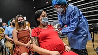A pregnant woman is inoculated with the Pfizer-BioNTech vaccine against COVID at a vaccination center in Medellin, Colombia.