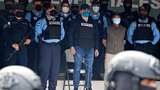 El expresidente Juan Orlando Hernández esposado de pies y manos y custodiado por varios agentes