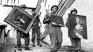Des troupes de l'armée des Etats-Unis récupérant des œuvres d'art volées par les Nazis près de la frontière suisse en Autriche, en mai 1945.