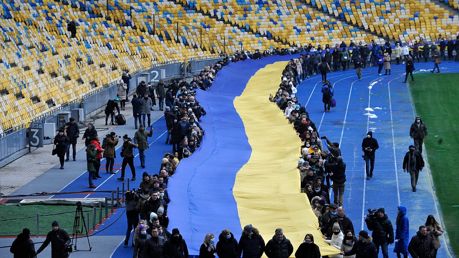 Ukrainians deploy a giant national flag in a Kyiv stadium
