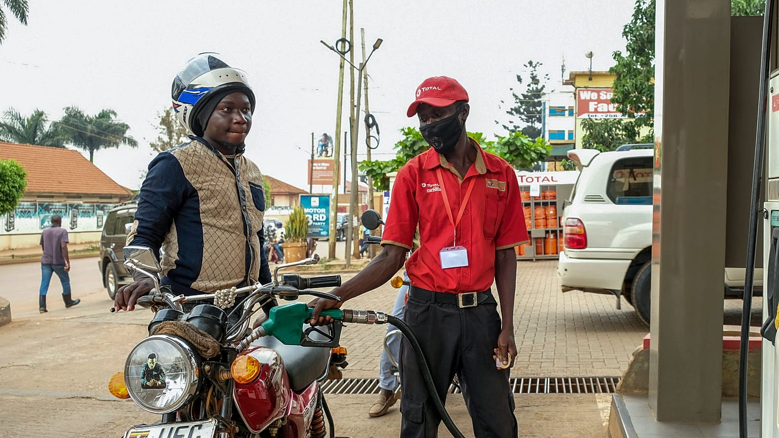 An attendant fuels a motorcycle at a Total gas station in the Kamwokya suburb of Kampala, Uganda Tuesday, Feb. 1, 2022. 