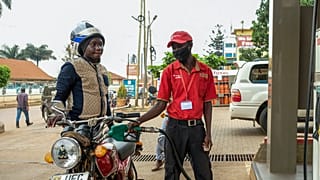 An attendant fuels a motorcycle at a Total gas station in the Kamwokya suburb of Kampala, Uganda Tuesday, Feb. 1, 2022.